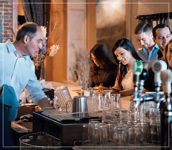 People enjoying drinks and conversation at a lively bar.