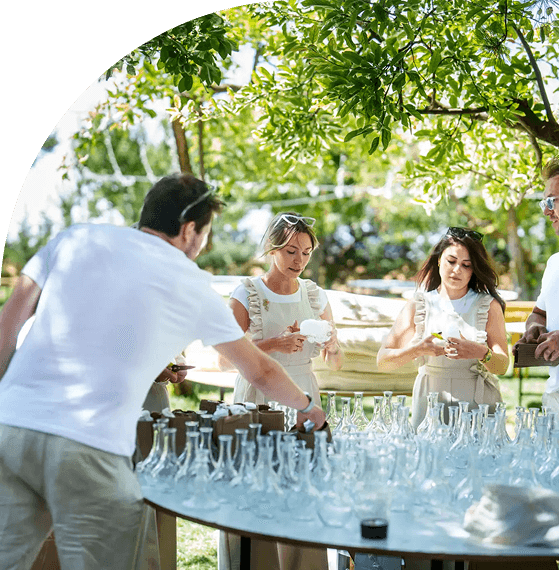 People serving drinks outdoors at a sunny event.