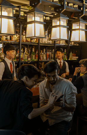Friends enjoying drinks and conversation in a warmly lit bar.