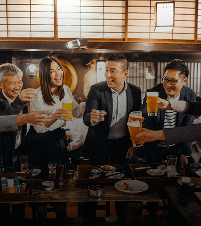 Group of friends enjoying drinks together at a lively restaurant.