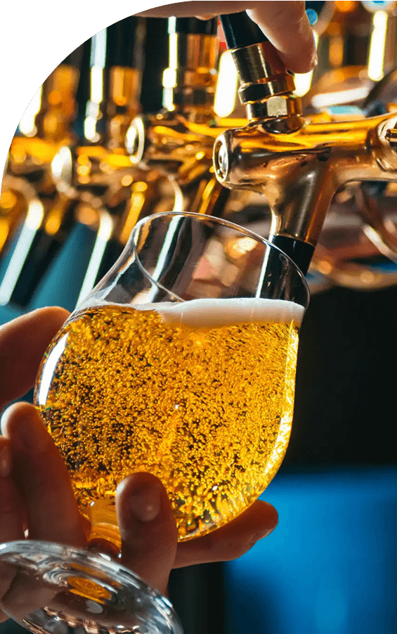 A close-up of beer being poured into a glass from a tap.